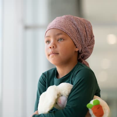 Young cancer patient looking out window.