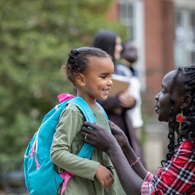 Mother sending daughter off to school.