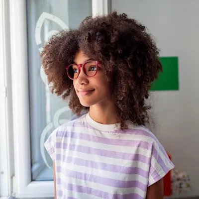 Happy teen looking out window.