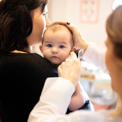 Provider looking at infant's ears.