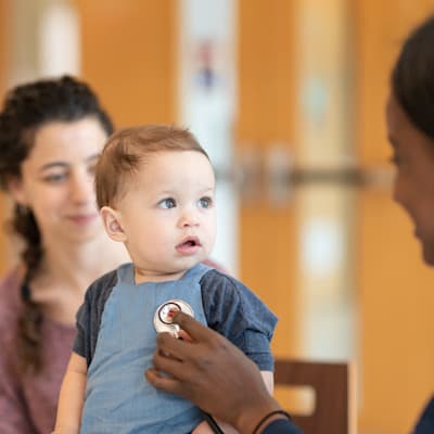 Provider listening to young girl's heart.