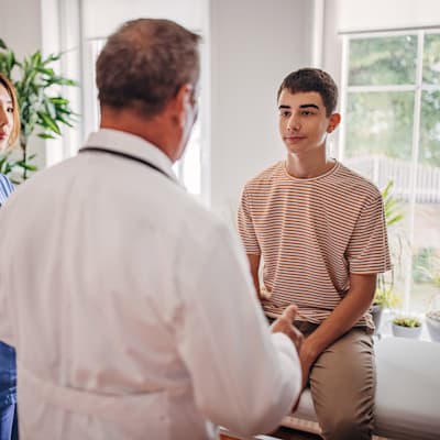 Teen boy talking with doctor.