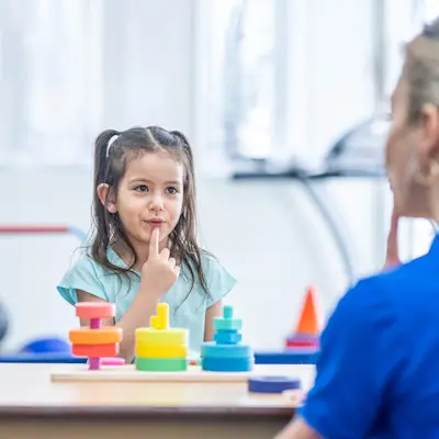 Young girl working with speech therapist.