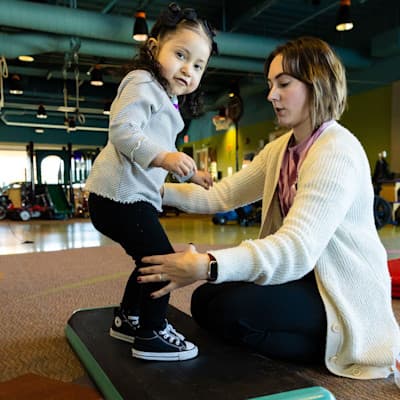 Provider helping young girl through exercise.