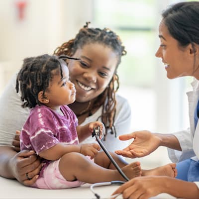 Provider making young infant smile.