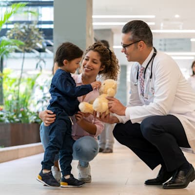 Mother and son talking to provider in hospital hallway.