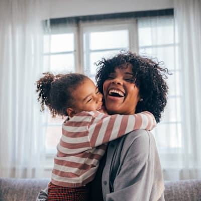 Young girl giving her mother a big hug.