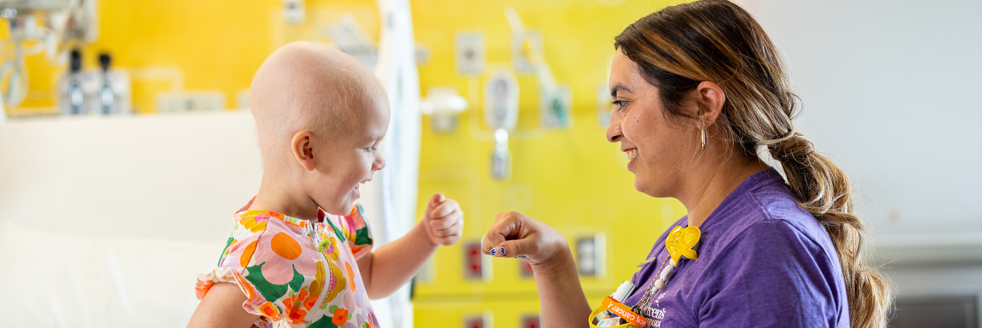 A smiling nurse giving a happy child a fist bump